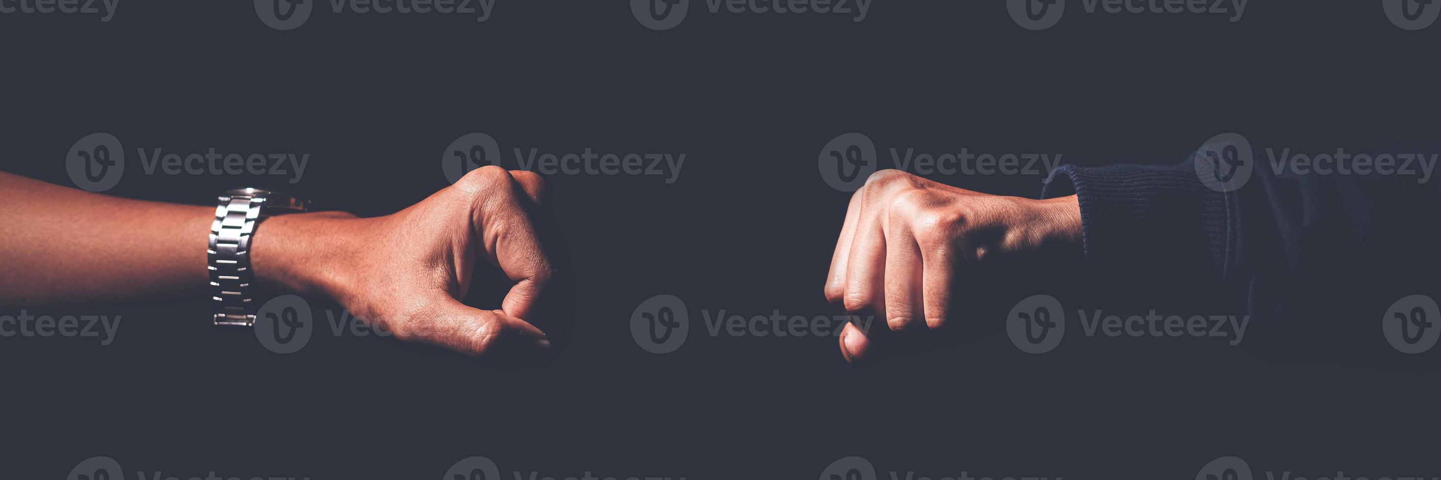 A shot crop of two fists smashing into each other to greet, challenge, fight, and duel. photo