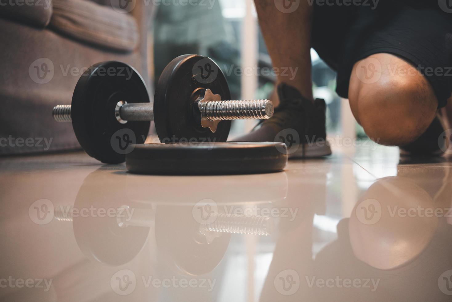 Fitness motivation and muscle training concept. Home workout routine fitness, Concepts of exercise and muscle training healthy.Dumbbell on the floor. photo