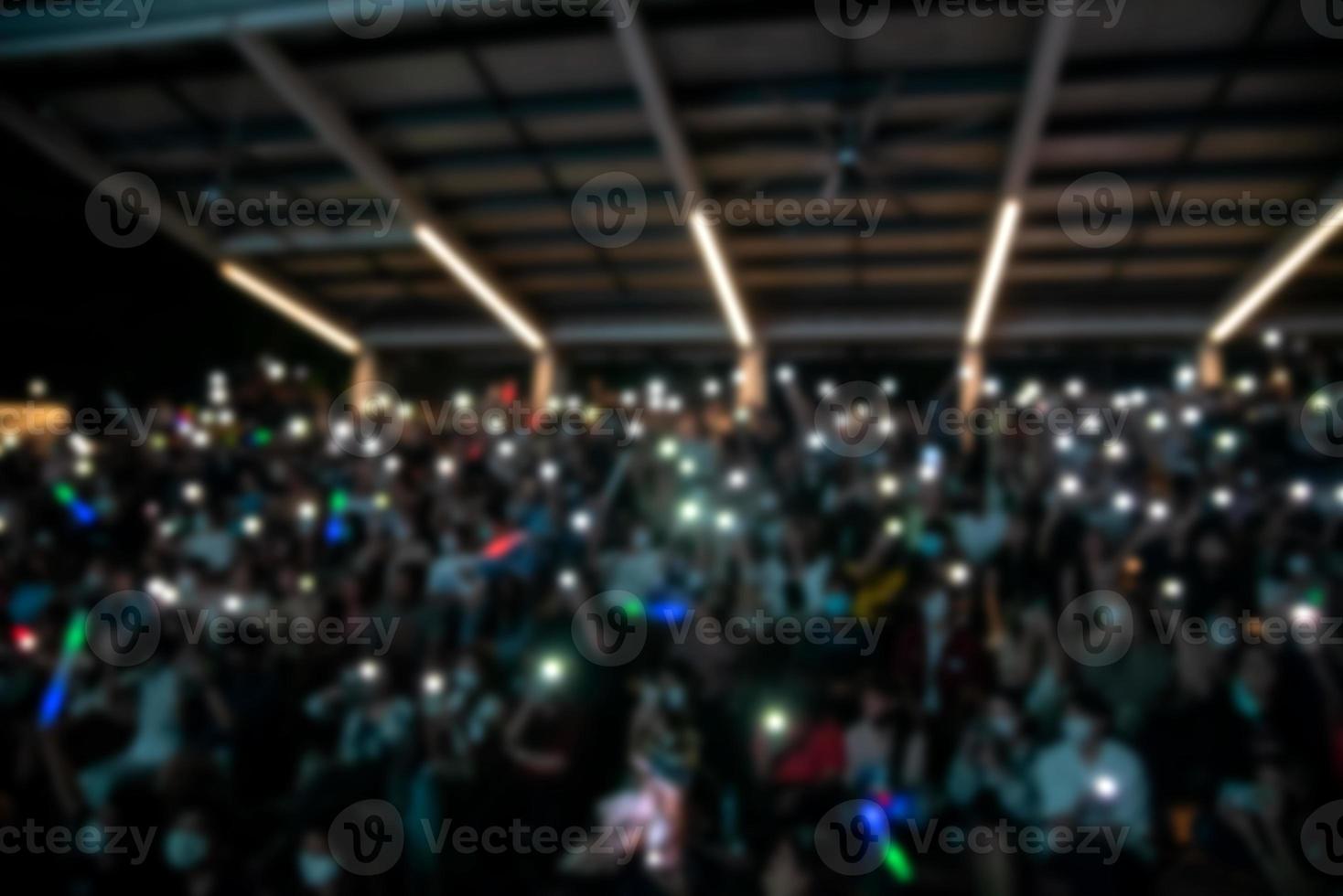 people holding cigarette lighters and mobile smartphones at a concert photo