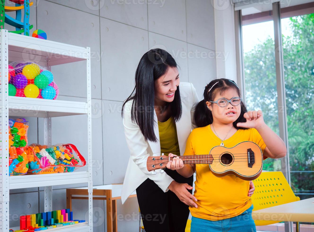 A cheerful group creative arts class for kids and their teacher in the school classroom, happy schoolkids playing an interesting board game during a lesson in the classroom photo