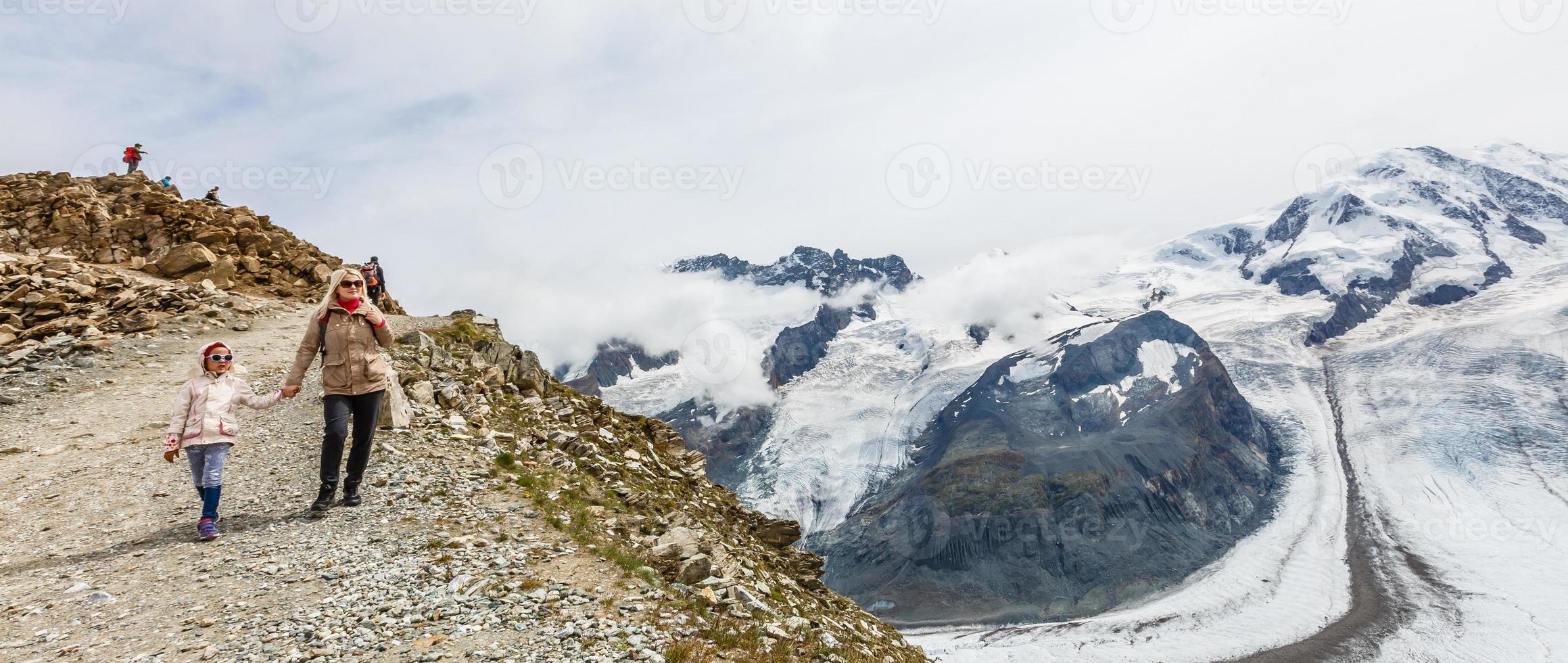 Mother and to children going for a walk in mountain surroundings photo