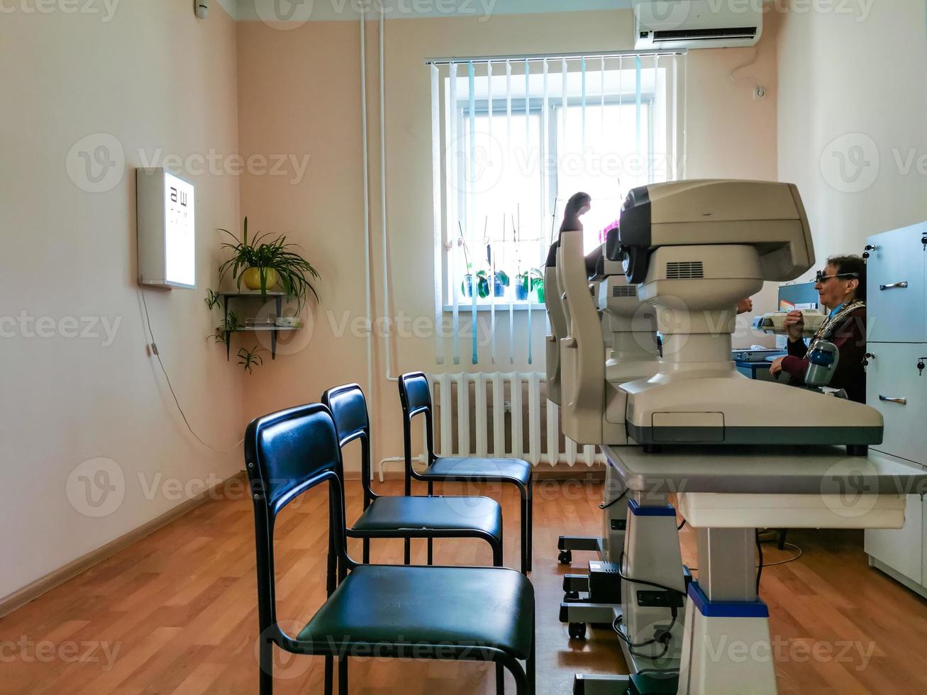 Ophthalmologist works with virtual tester for vision checking looking at the camera and smiling. Ophthalmology, medicine and health concept. photo