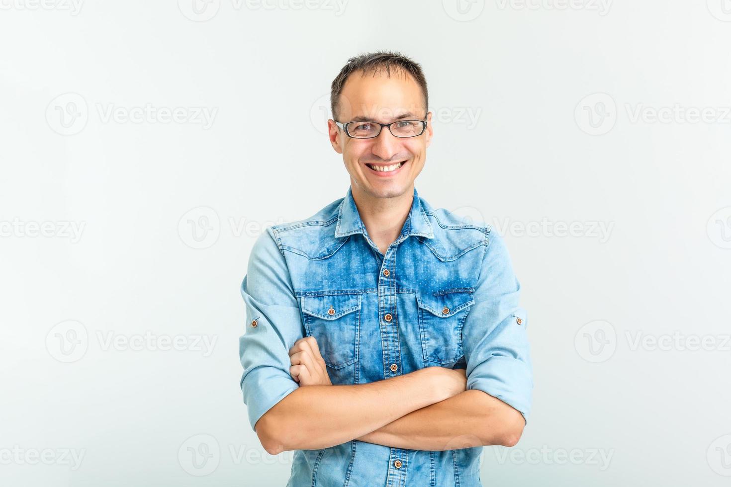 A goofy man wearing trendy nerd glasses isolated over white with a funny expression on his face. photo