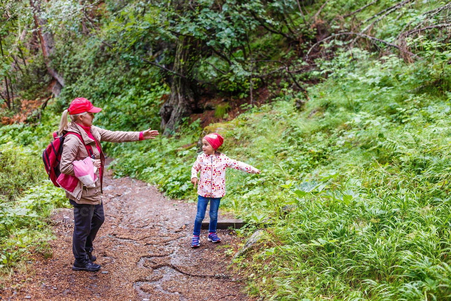 Hikers with backpack looking at mountains, alpine view, mother with child photo
