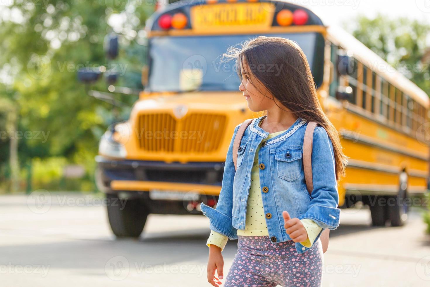 niña con mochila va al autobús escolar foto