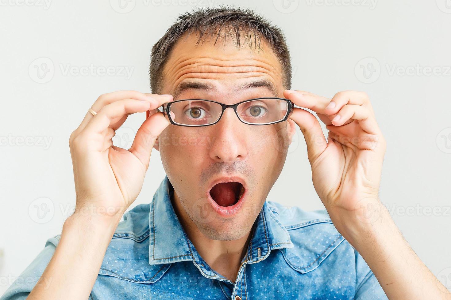 Closeup portrait of frustrated, mad angry nerdy young man with big glasses, screaming fists raised, isolated on white background. Negative emotions facial expressions feelings, body language photo