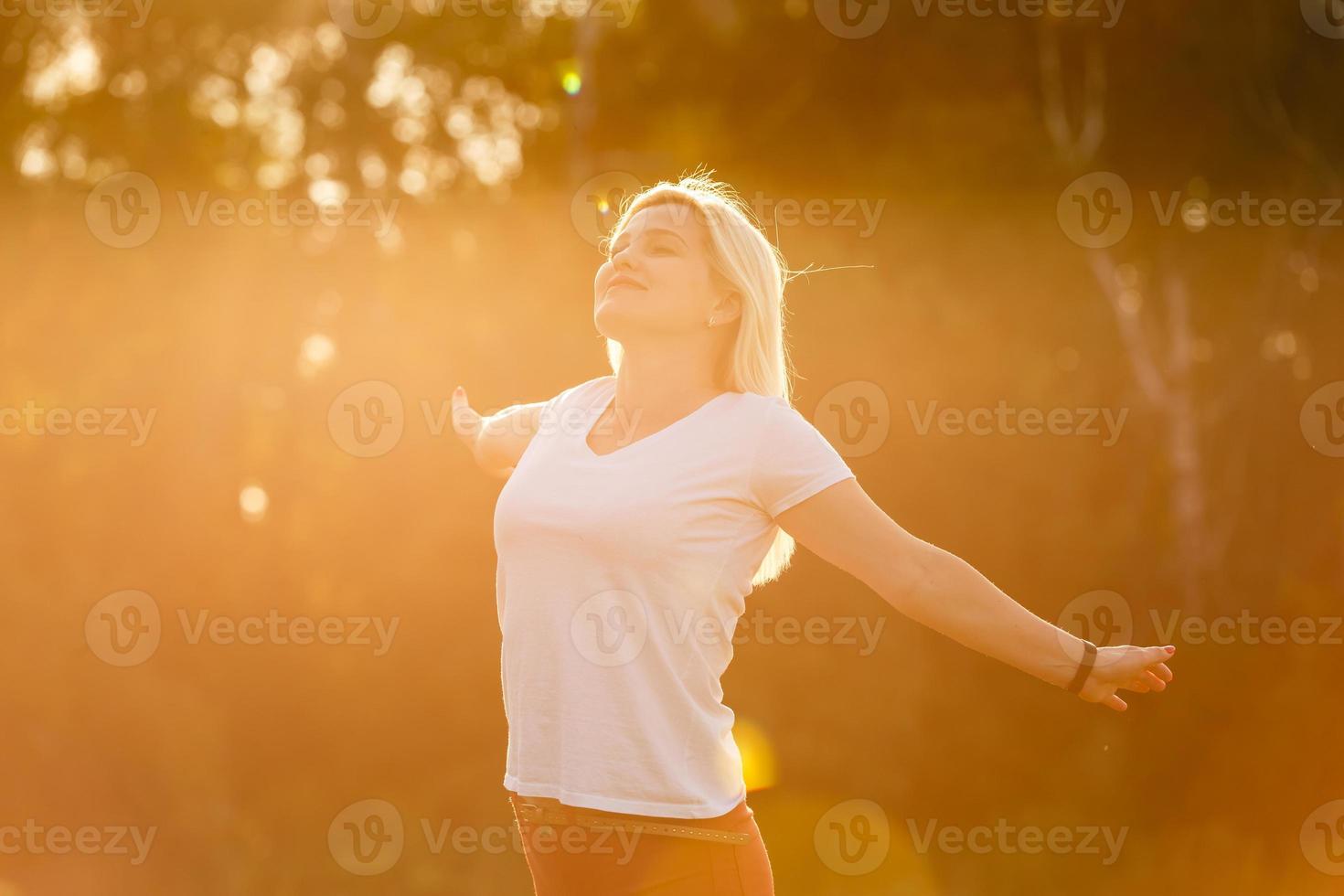 mujer feliz libre disfrutando de la naturaleza. chica de belleza al aire libre. concepto de libertad. chica de belleza sobre el cielo y el sol. rayos de sol disfrute foto