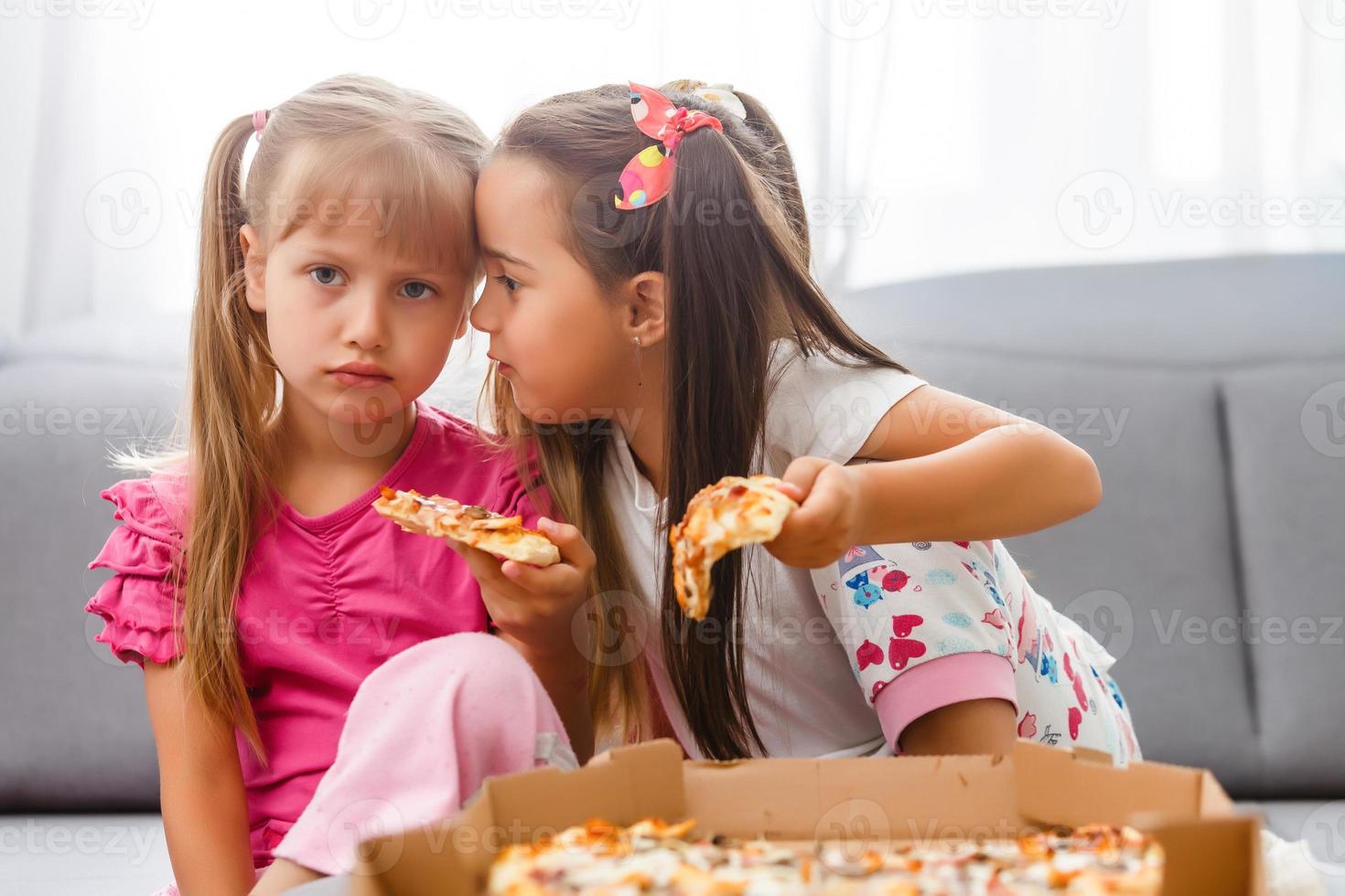 little bored girls eating pizza at home photo