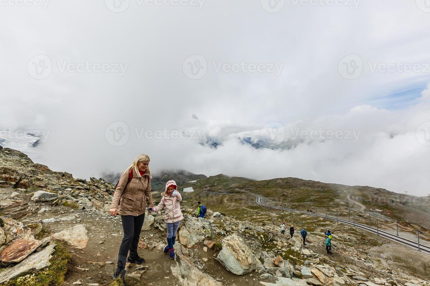 Mother and to children going for a walk in mountain surroundings photo