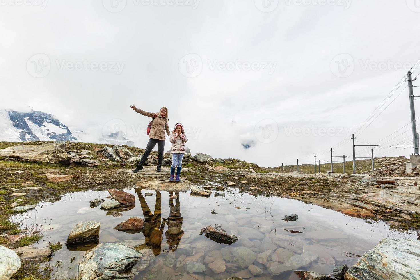 Mother and to children going for a walk in mountain surroundings photo