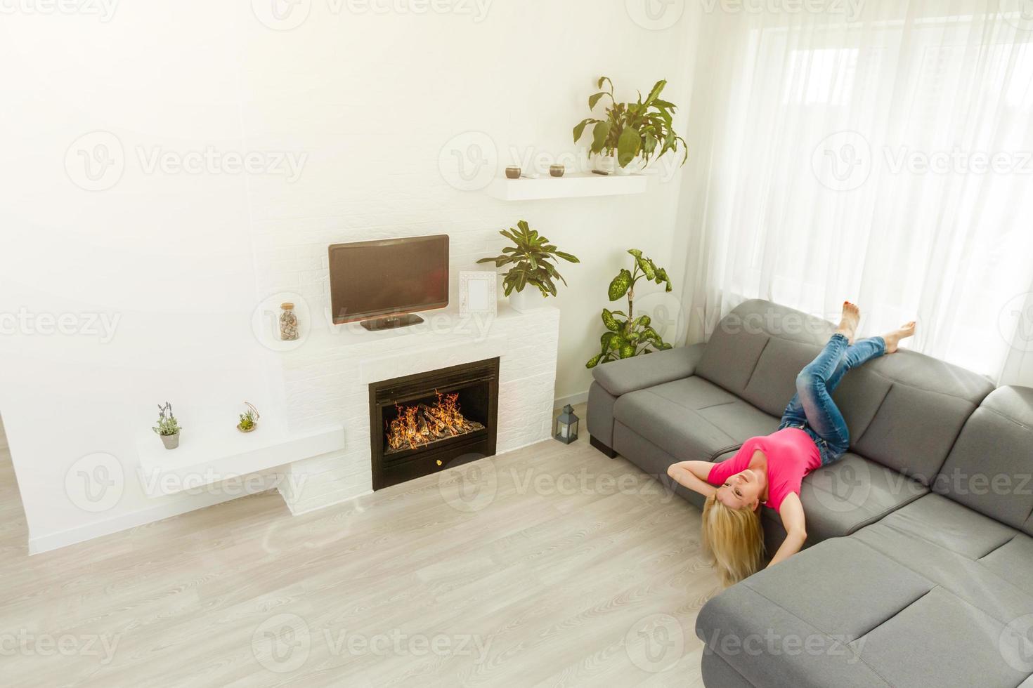 Portrait of a girl relaxing on a sofa after work at home sitting on a sofa in the living room at home with a warm light of sunset photo