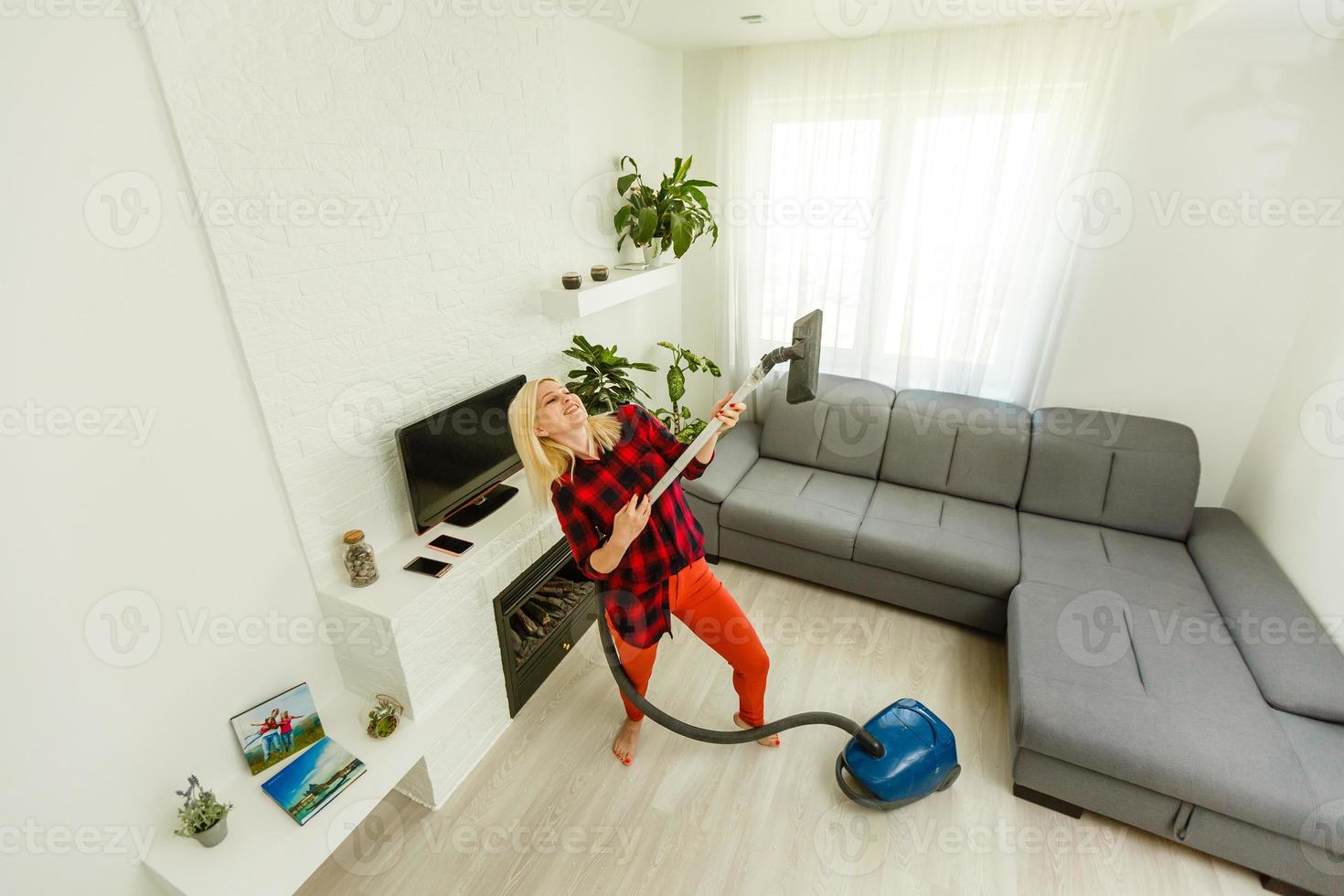 Young woman using vacuum cleaner at home photo