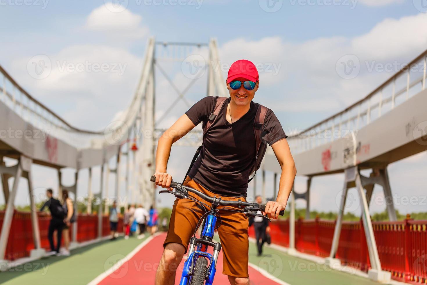 man standing on a bridge with bicycle photo