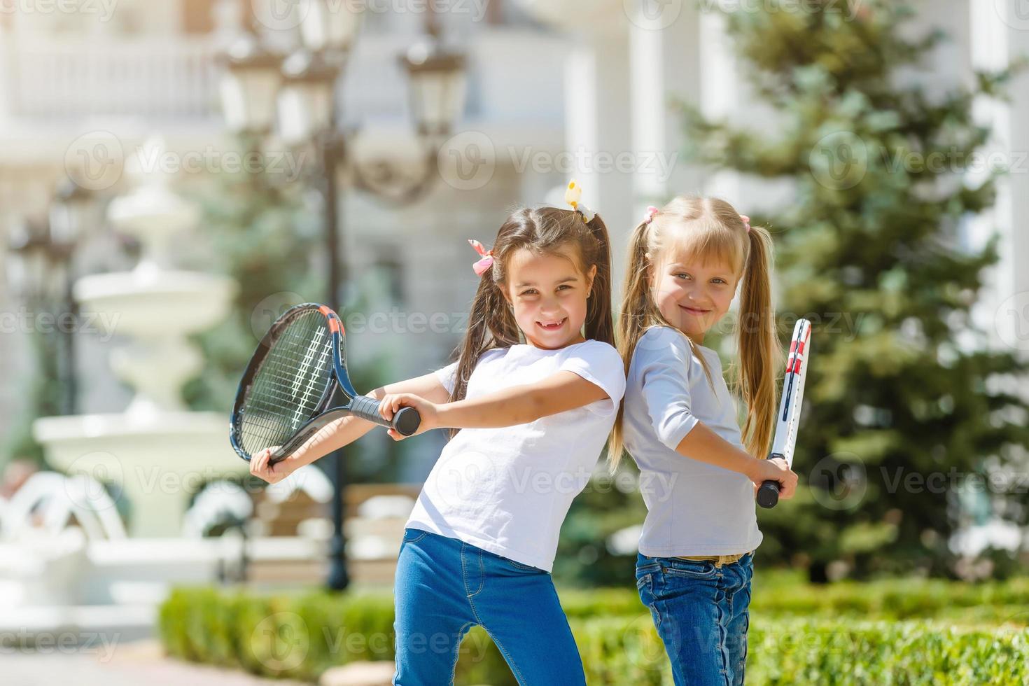 two little girls with tennis rackets photo