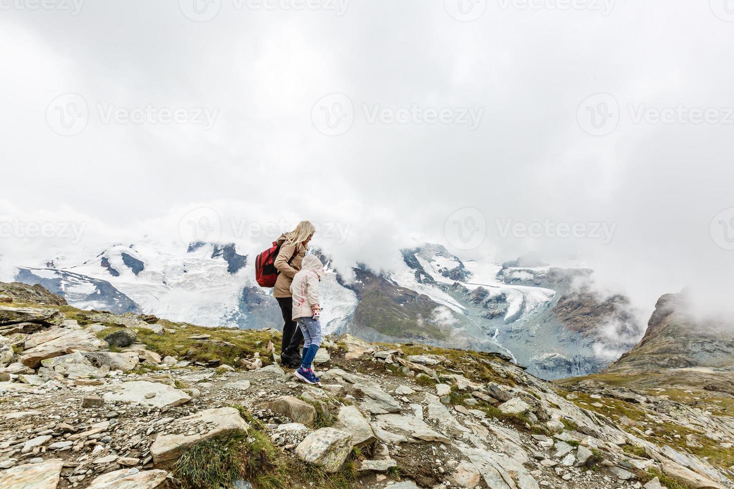 Mother and to children going for a walk in mountain surroundings photo