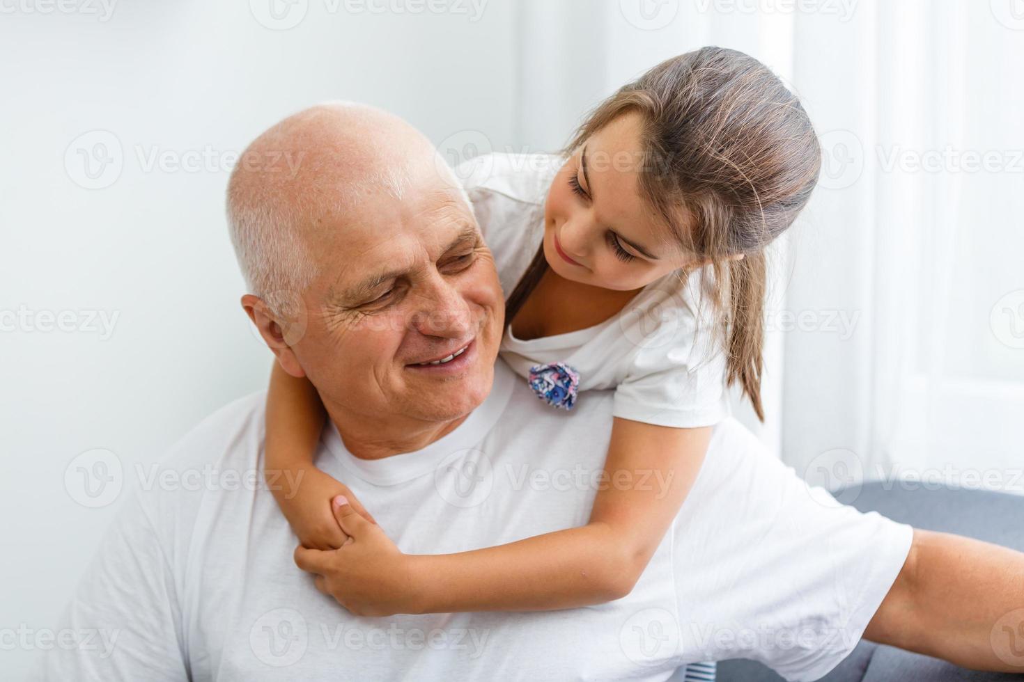 Happy grandfather and granddaughter together at home. Close up. photo