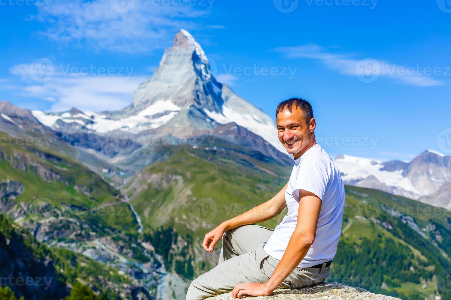 Hiker poses in front of mountain peaks range hiking backpacker old older aarp strong strength vital energetic landscape photography portrait background colorful adventure retired retirement outdoor photo