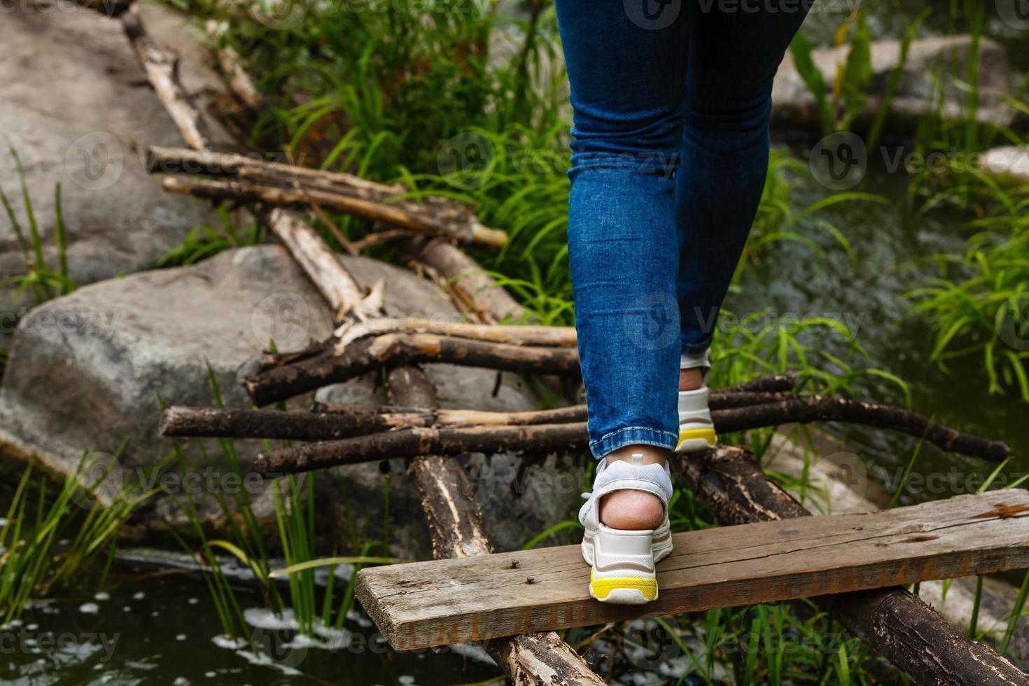 mujer camina sobre escalones cruzando el río. foto