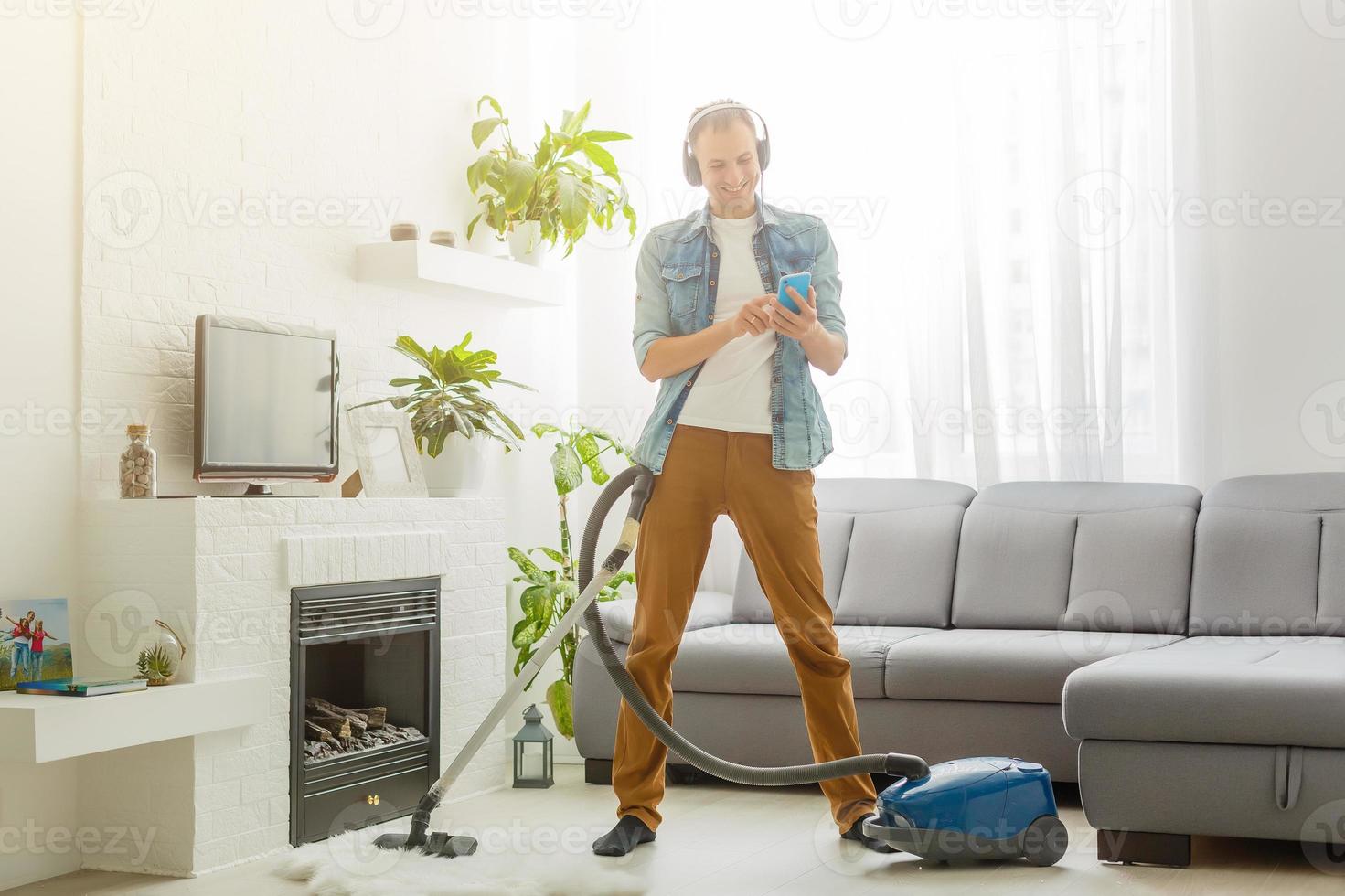 Coronavirus pandemic. A man with a vacuum cleaner in his apartment. Home Office. Quarantine. Remote work. A man in a business shirt and underpants holds. photo