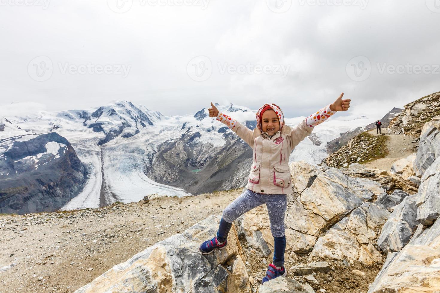 Children hiking in Alps mountains. Kids look at mountain in Austria. Spring family vacation. Outdoor fun and healthy activity. photo