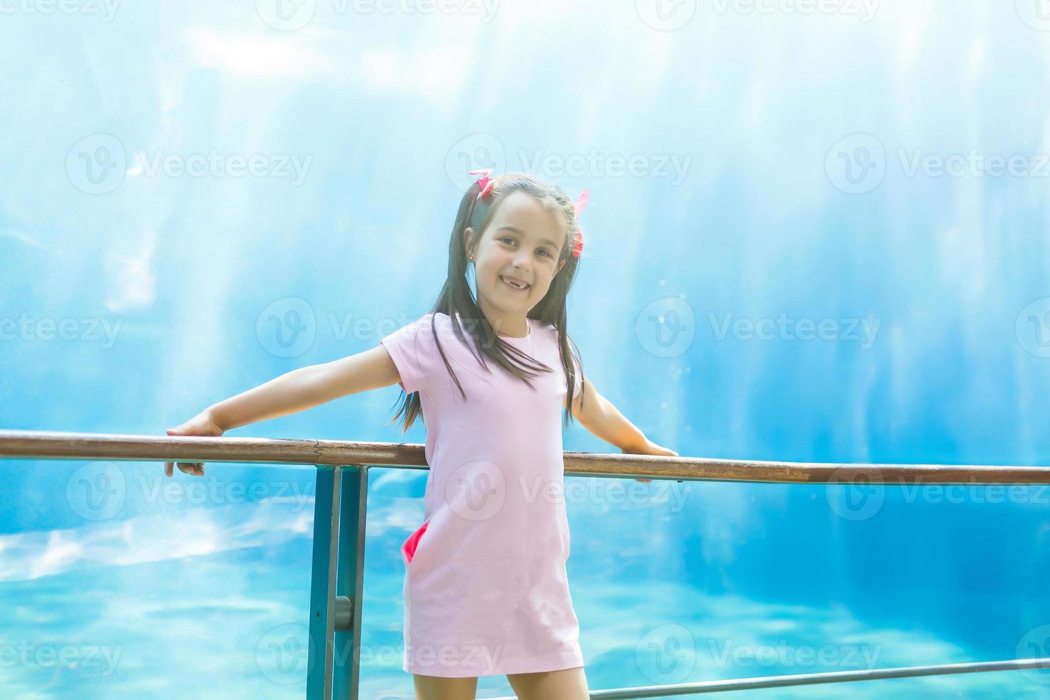 una niña busca peces en un acuario enorme foto