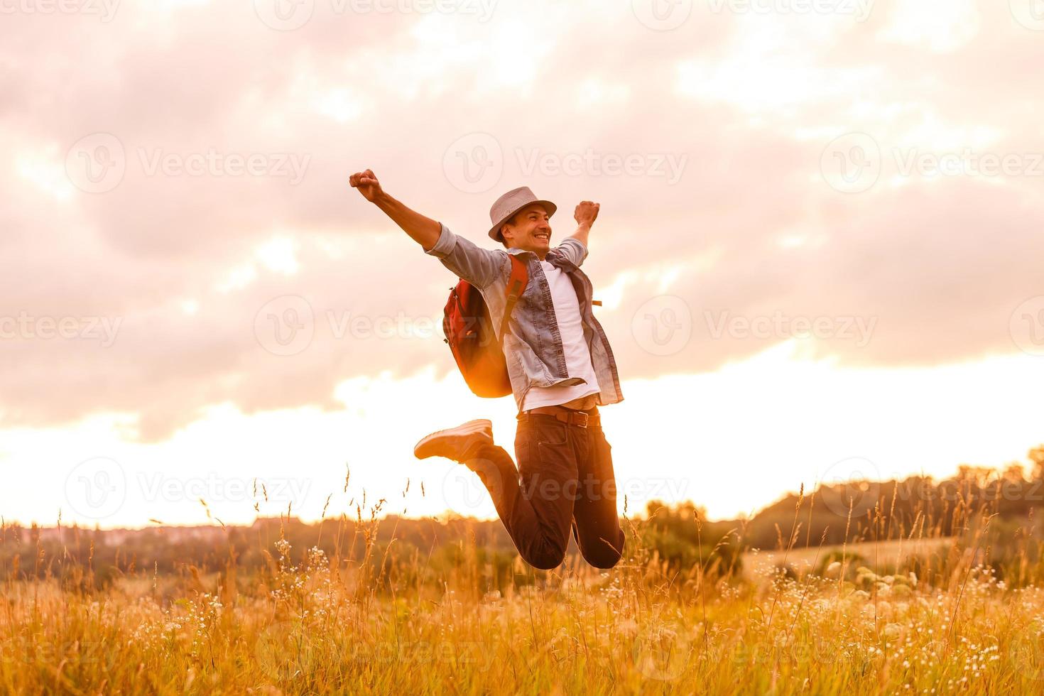 Getting away from it all. Man in open field relaxing looking at the beautiful view. photo