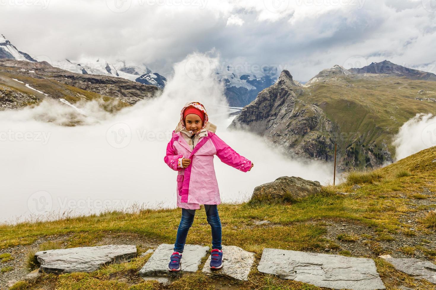 Children hiking in Alps mountains. Kids look at mountain in Austria. Spring family vacation. Outdoor fun and healthy activity. photo