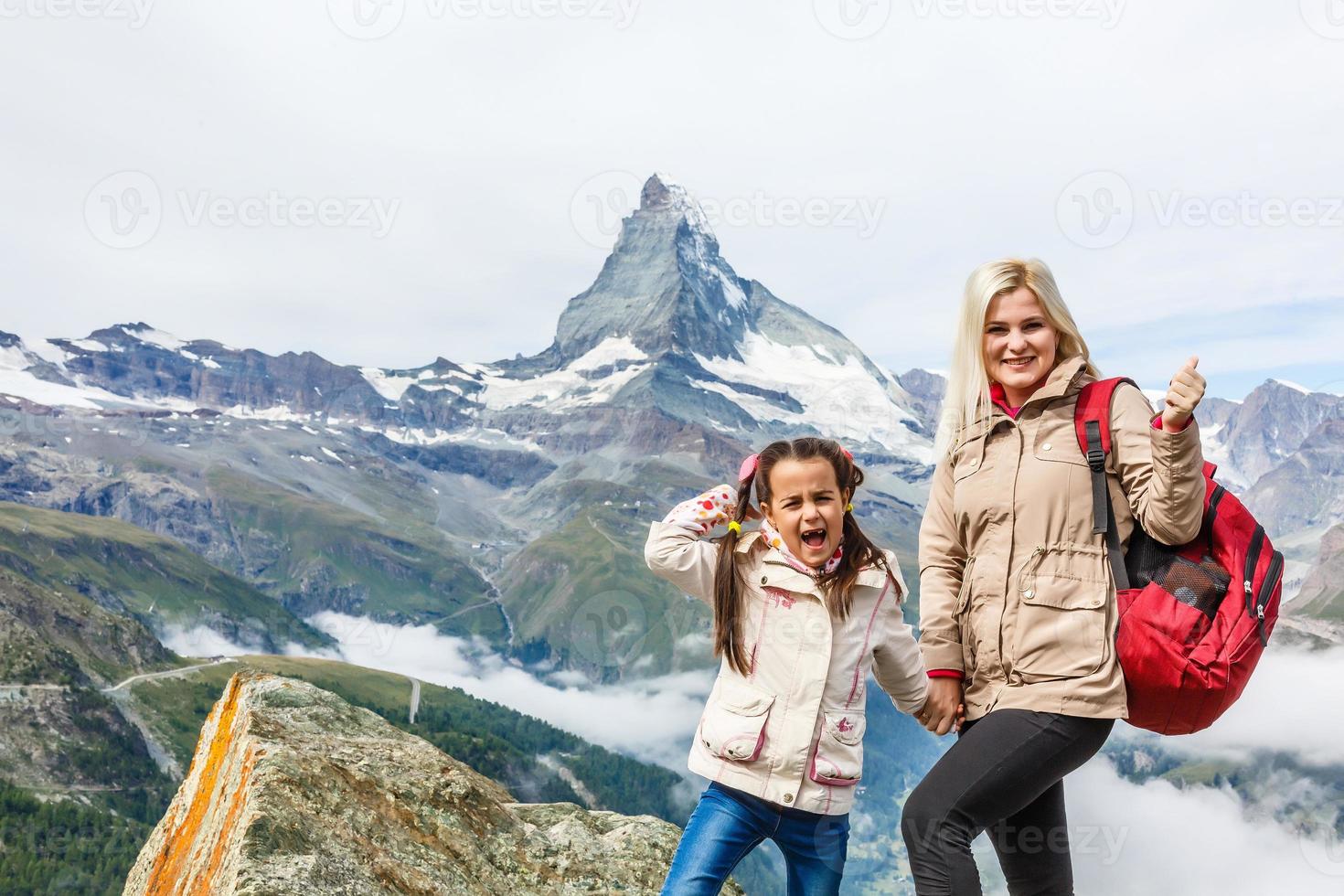 Happy hiker woman and girl at mountains lake photo