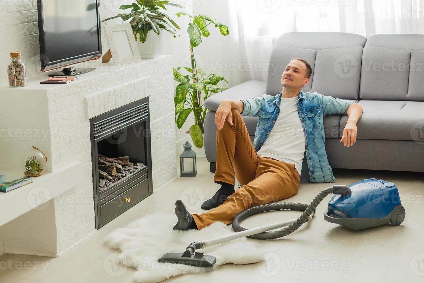 Coronavirus pandemic. A man with a vacuum cleaner in his apartment. Home Office. Quarantine. Remote work. A man in a business shirt and underpants holds. photo