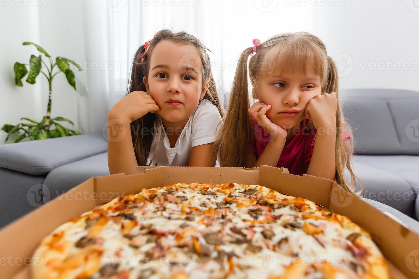 little bored girls eating pizza at home photo