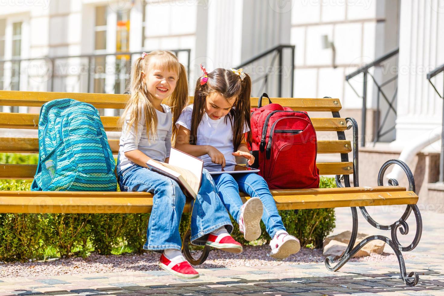 De vuelta a la escuela. niños felices listos para la escuela primaria. alumno el primer día de clases. chica con mochila y libro en el patio trasero. educación para niños de jardín de infantes y preescolar. foto