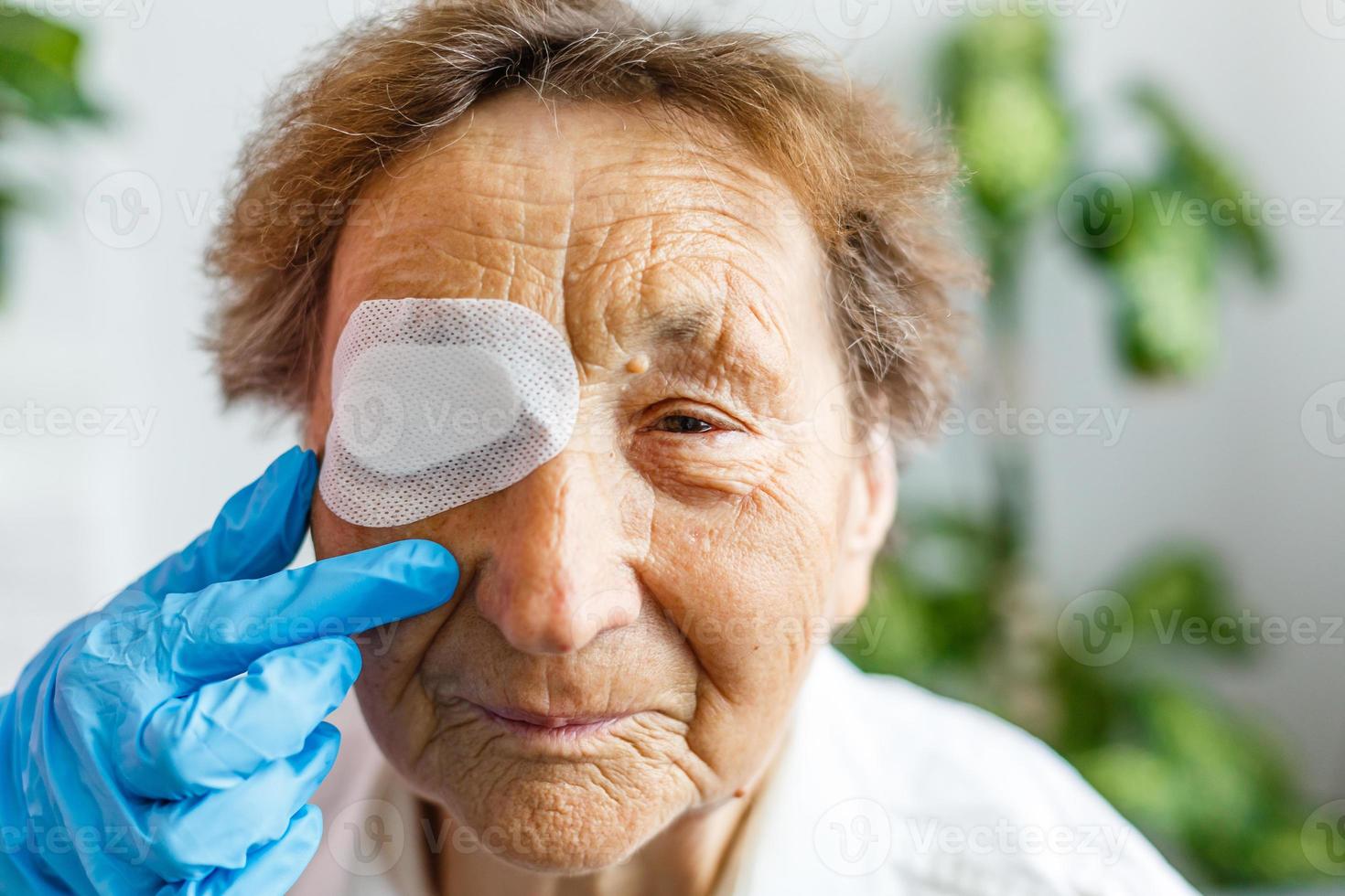 Close up picture of an elderly woman's injured eye and nurse's fingers photo