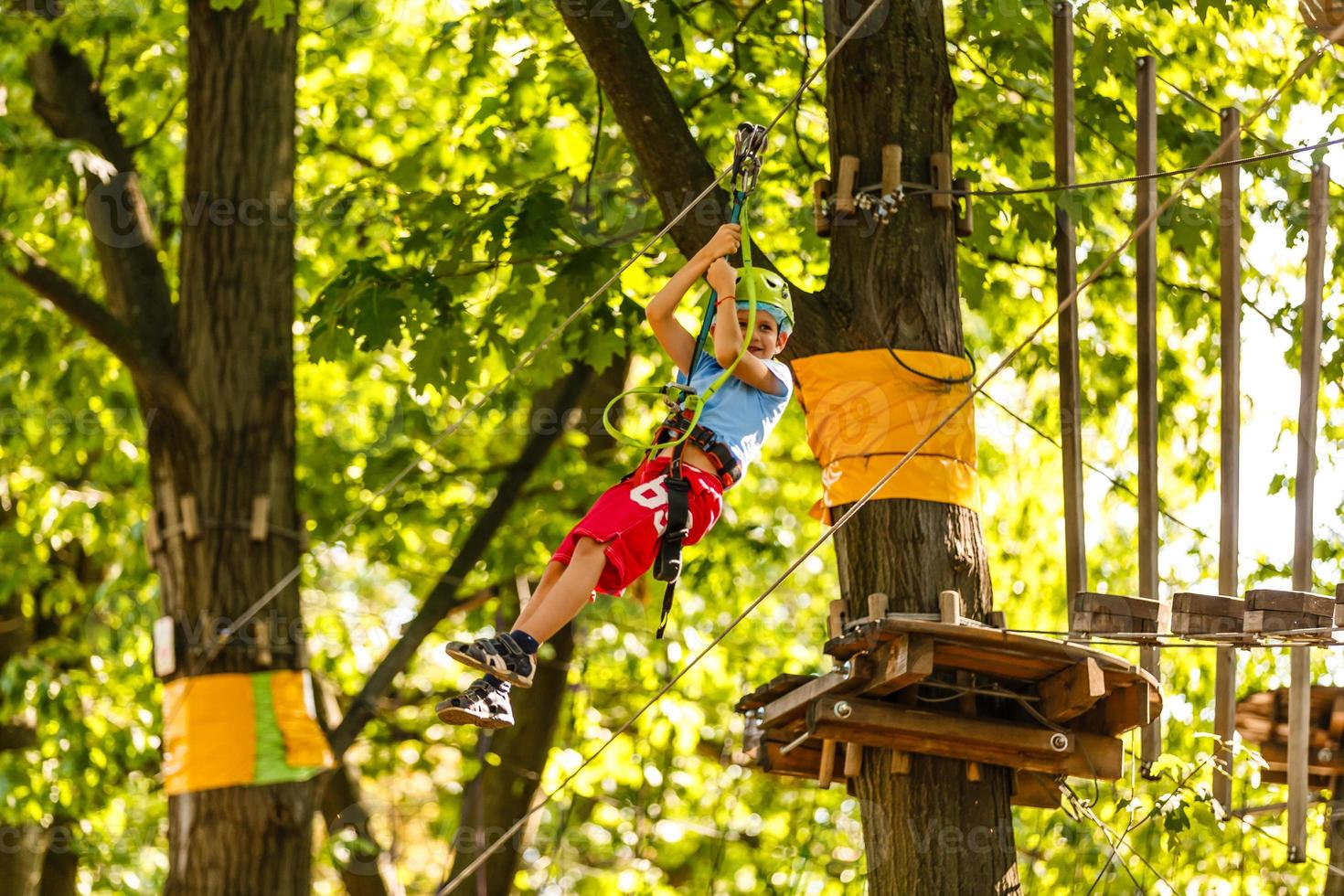 happy little children in a rope park on the wood background photo