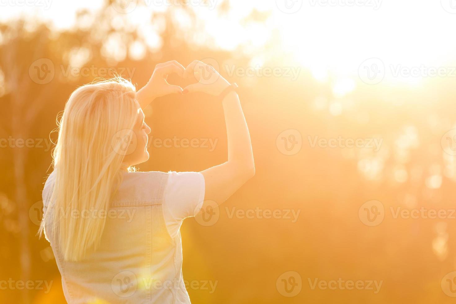 Attractive young woman enjoying her time outside in park with sunset in background. photo