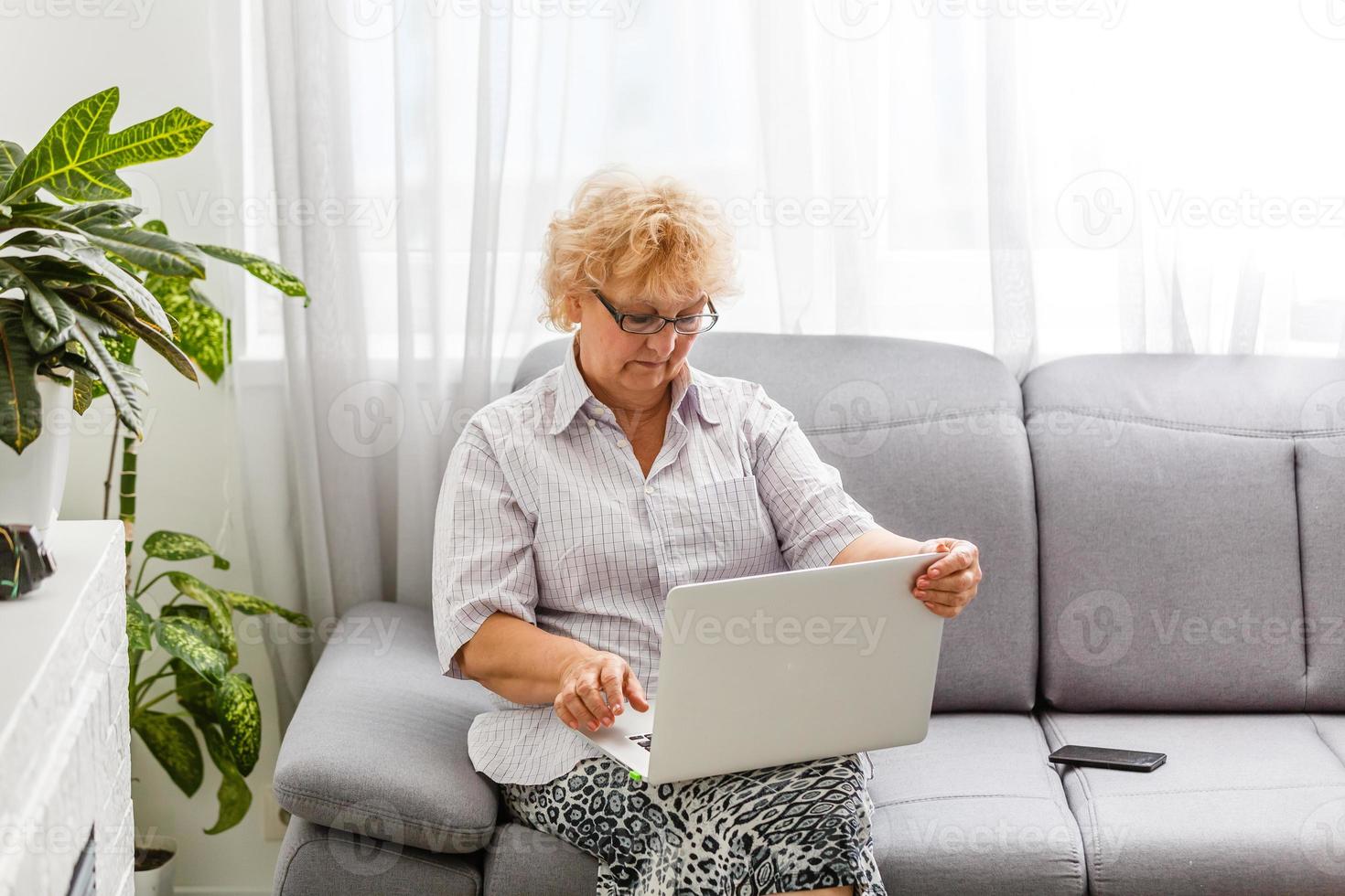 Happy mature middle aged elderly business woman winner excited by reading good news looking at laptop, glad senior older lady watching celebrating online bid bet win or great result victory concept photo