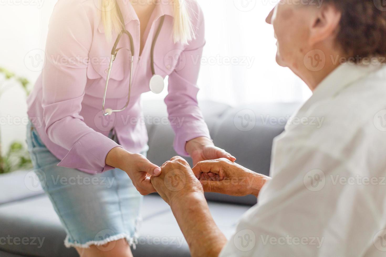 retrato de un joven médico y un paciente mayor sentados en el sofá foto