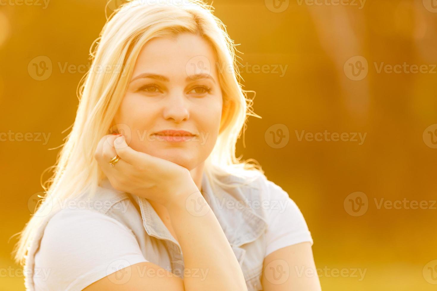 mujer feliz relajándose en el césped. cerrar la cara de una mujer rubia sonriendo y mirando a la cámara. mujer i en un día de verano. foto