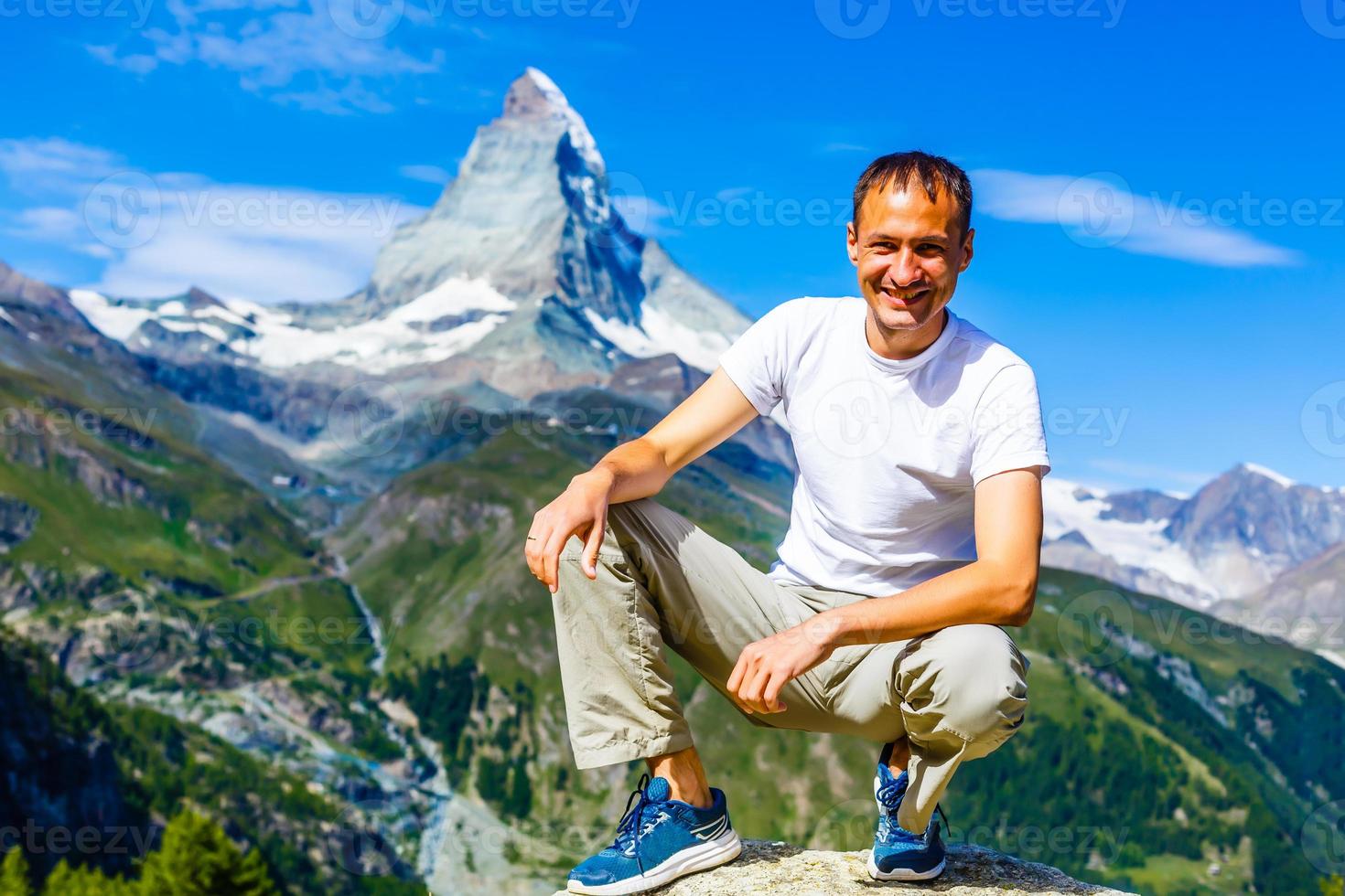 Hiker poses in front of mountain peaks range hiking backpacker old older aarp strong strength vital energetic landscape photography portrait background colorful adventure retired retirement outdoor photo