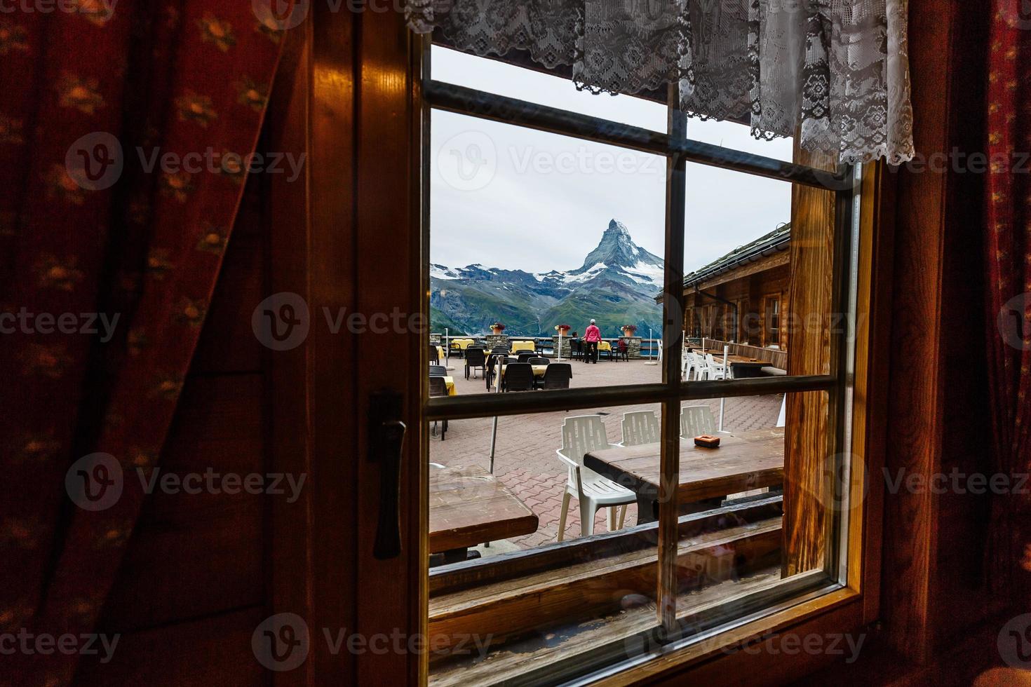 beautiful view of restaurant surround by mist lake and mountains with empty table photo