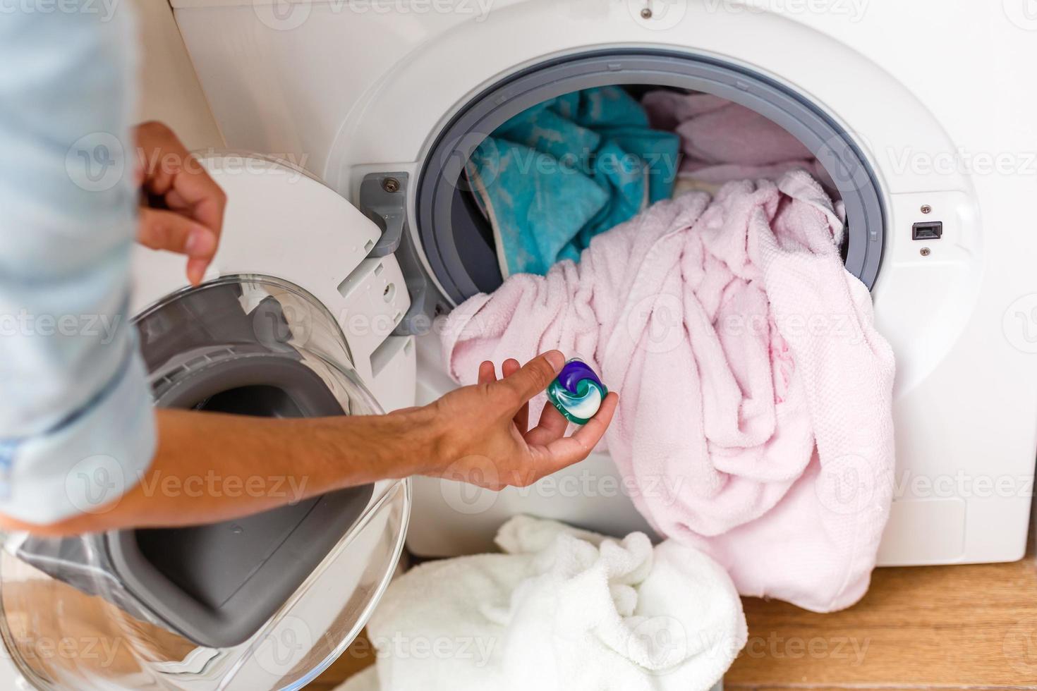 blue gel caps in hand for washing mashine, liquid coloured detergent photo