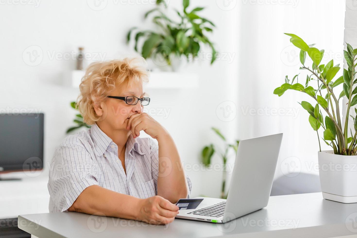 mature woman online banking, holding credit card 16782189 Stock Photo at Vecteezy