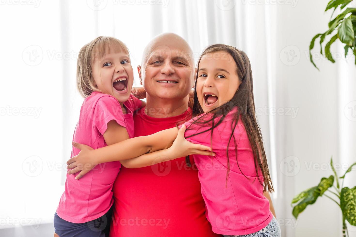 Mature man playing with granddaughters at home. photo