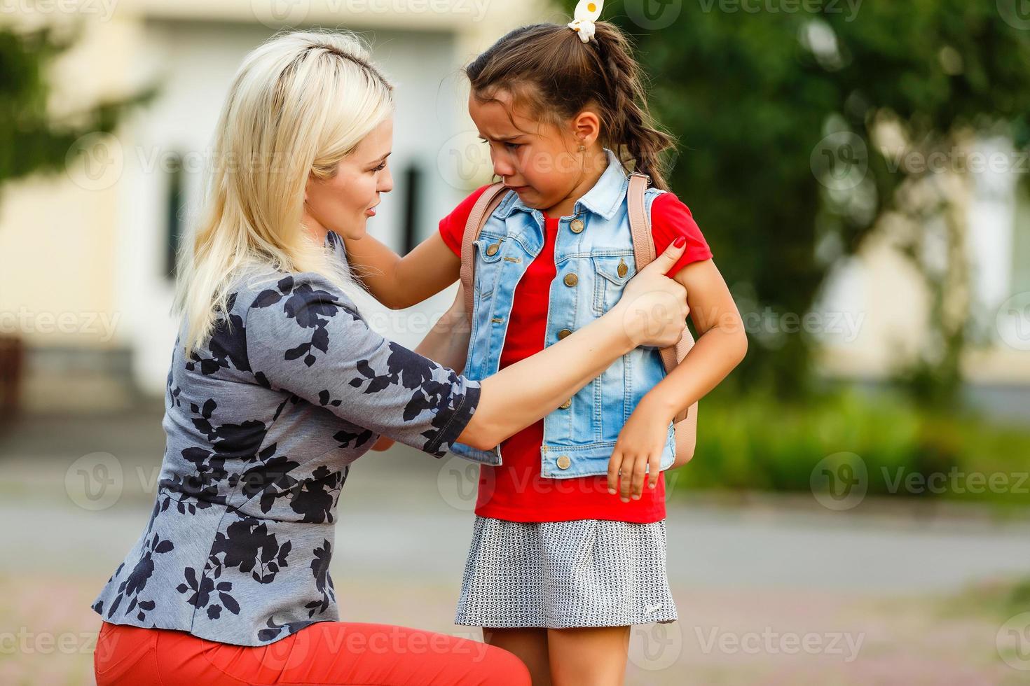 teacher consoling a girl on schoolyards photo