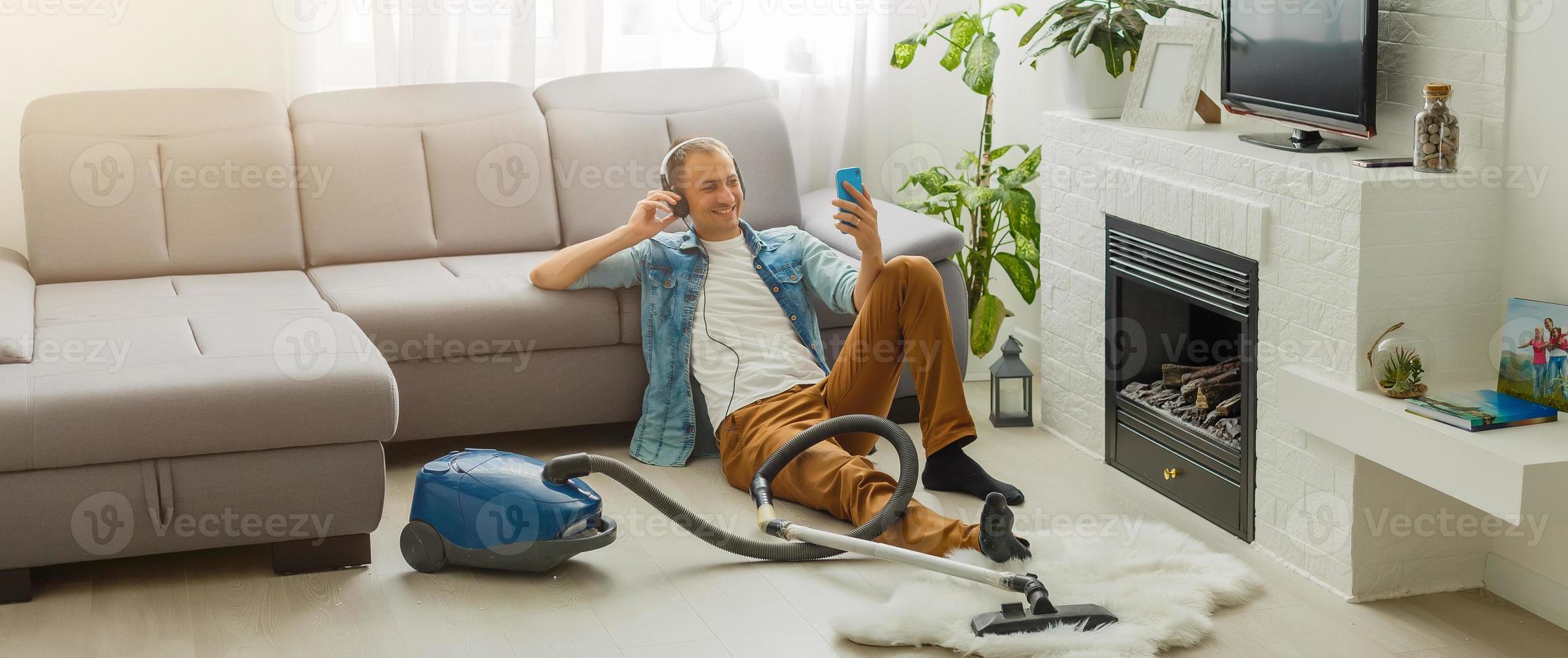 Coronavirus pandemic. A man with a vacuum cleaner in his apartment. Home Office. Quarantine. Remote work. A man in a business shirt and underpants holds. photo