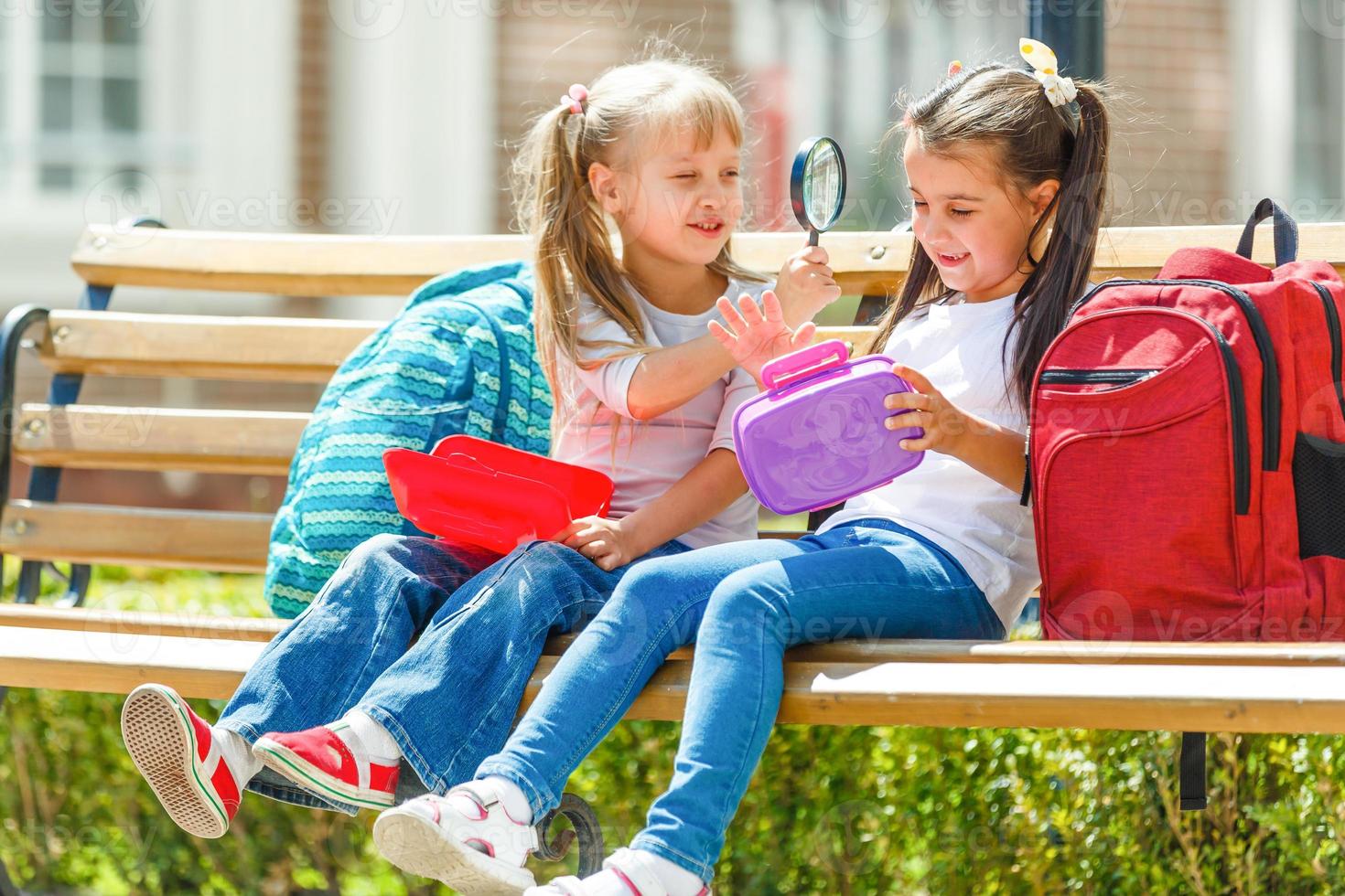 Elementary school kids sitting with packed lunches photo