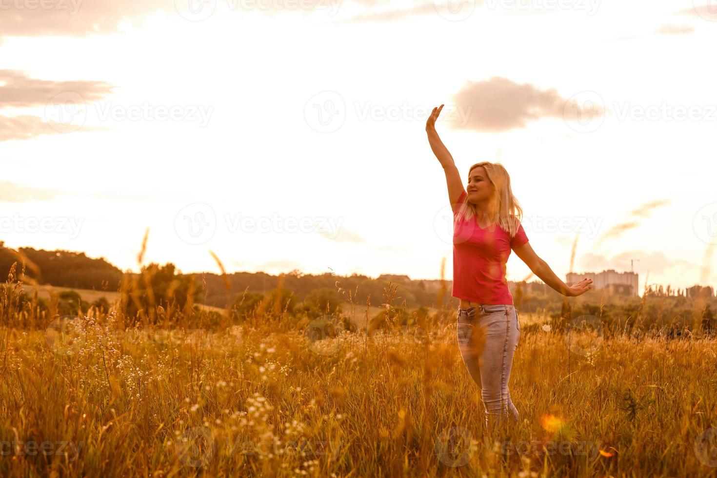 Woman silhouette waiting for summer sun on meadow photo