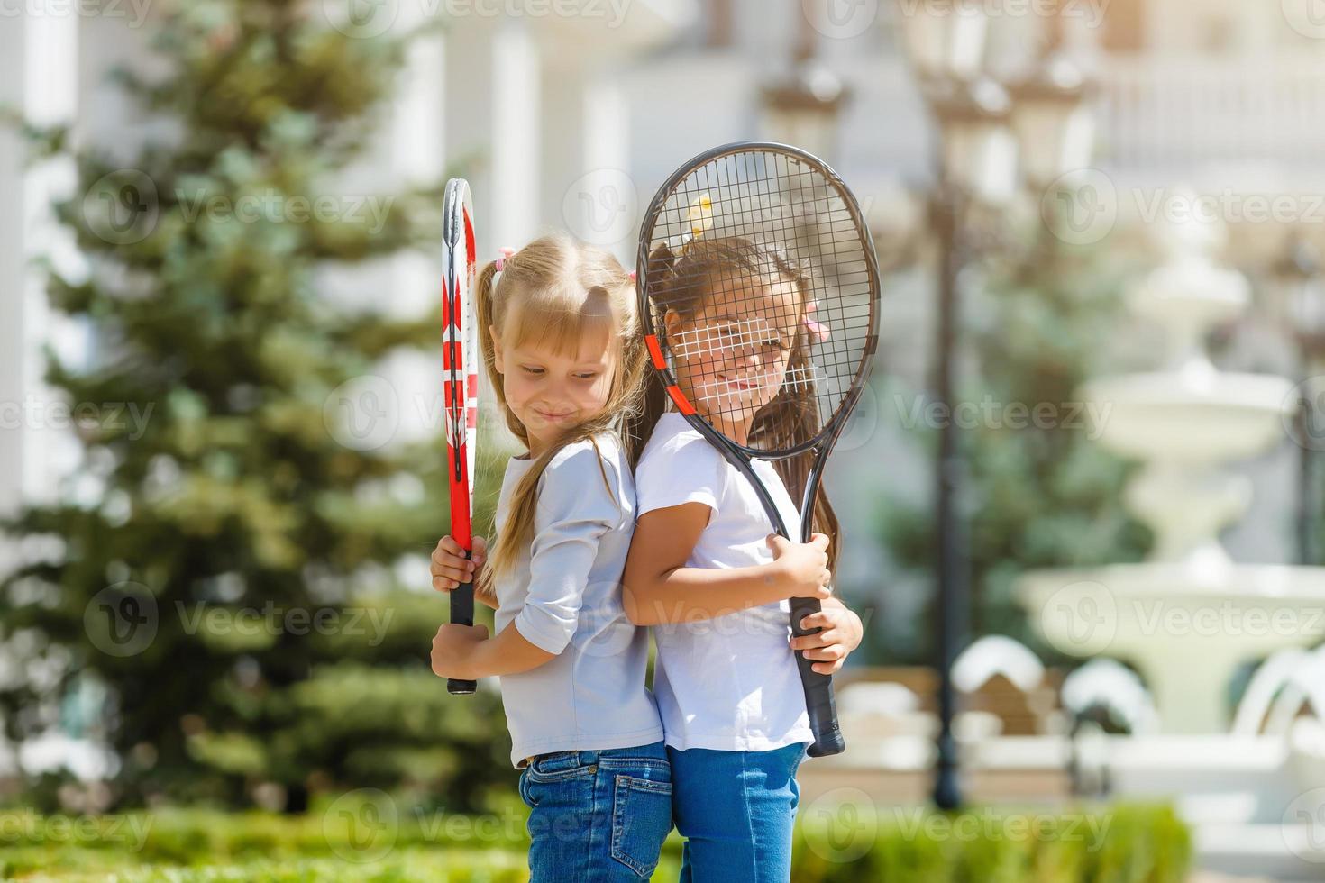 two little girls with tennis rackets photo