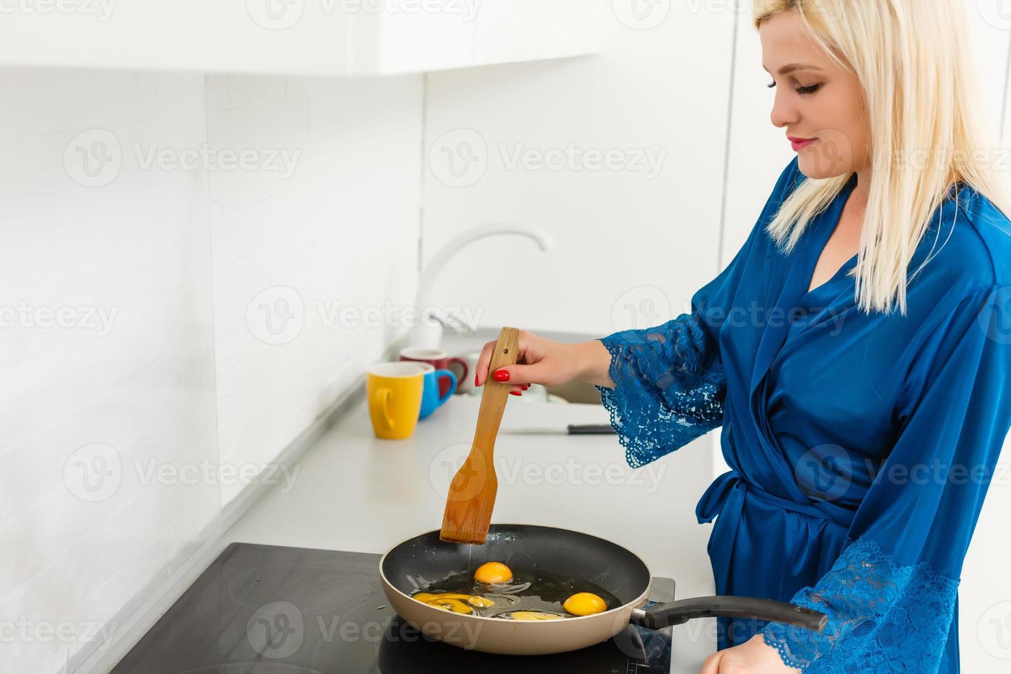 Woman preparing an egg in a frying pan photo