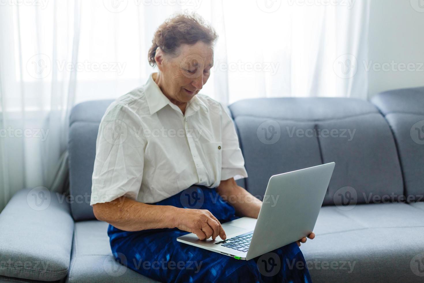 Smile senior sitting using laptop photo