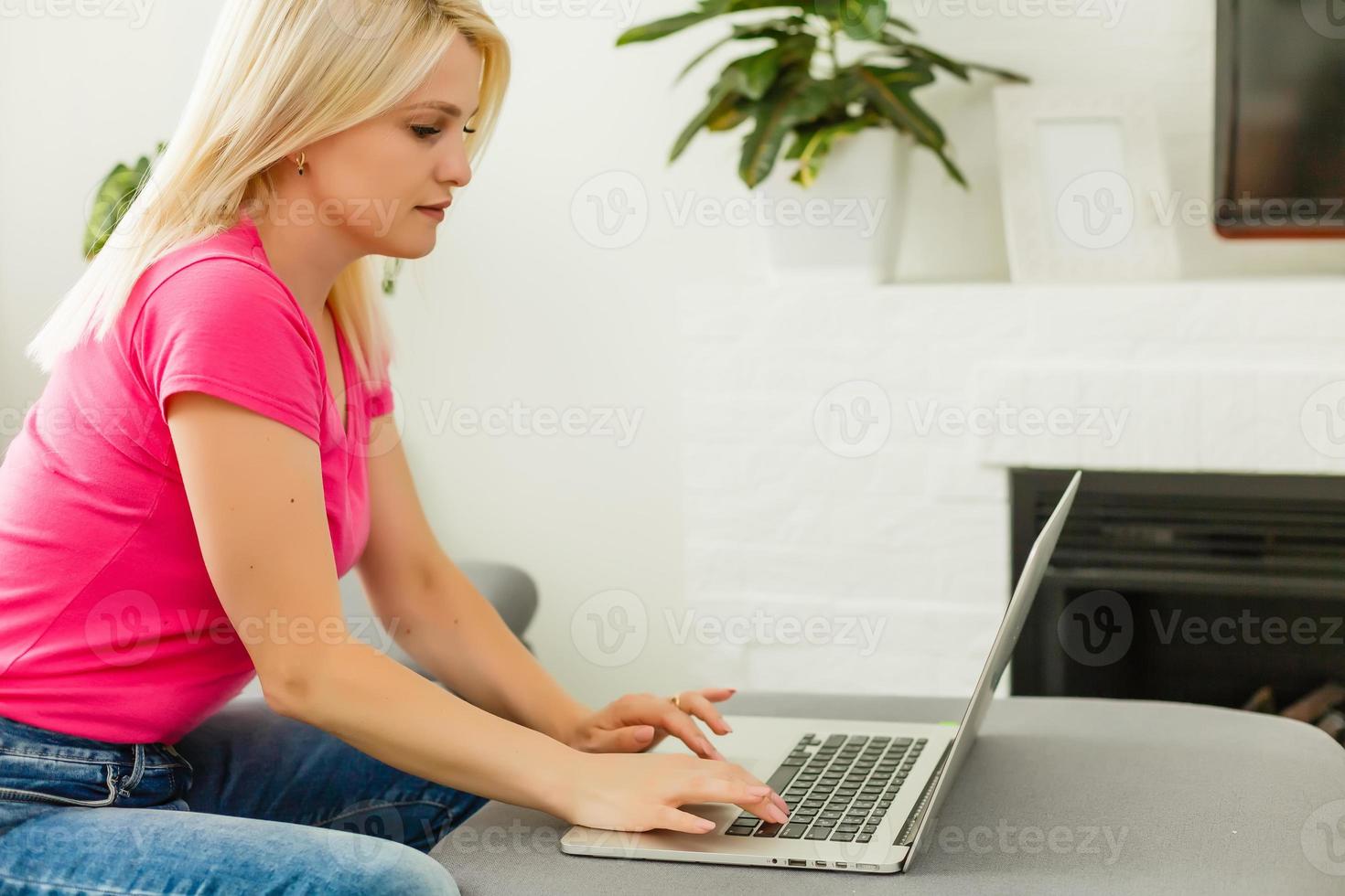 mujer joven con laptop trabaja en casa foto
